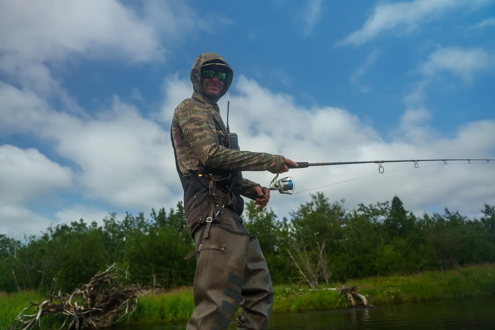 Guide in camo and waders casting for salmon on the river