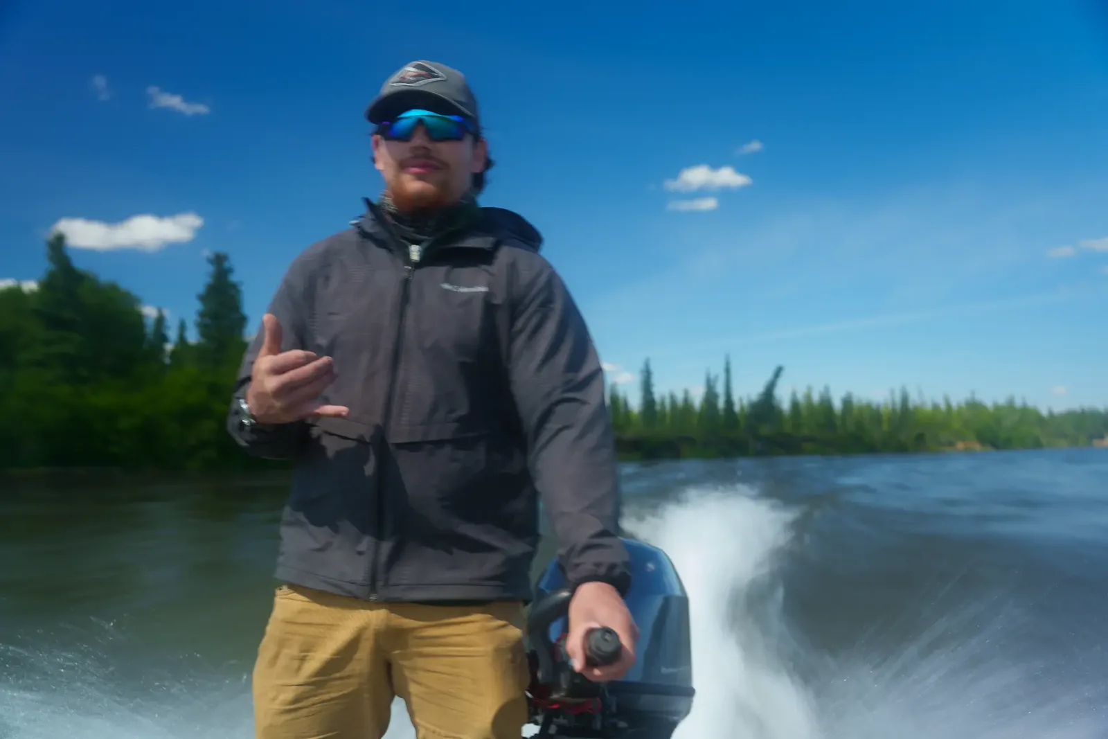 Guide driving the outboard motor on a sunny run up the river